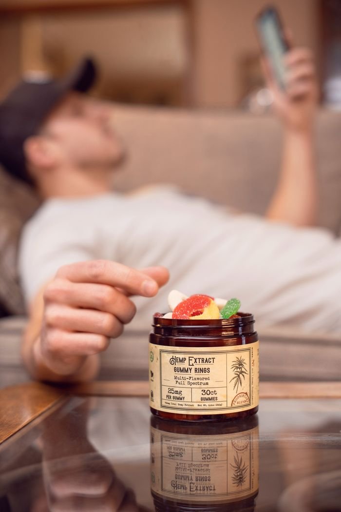A relaxed individual enjoying hemp extract gummy rings at home in Denver.